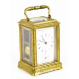 A late 19th century French engraved brass eight day carriage clock, the enamel dial with Roman