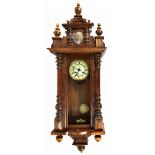 A late 19th century beech wood Vienna type wall clock, with applied lion head surmount to the