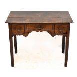 A George III oak low boy with an arrangement of three drawers raised on square sectioned tapering
