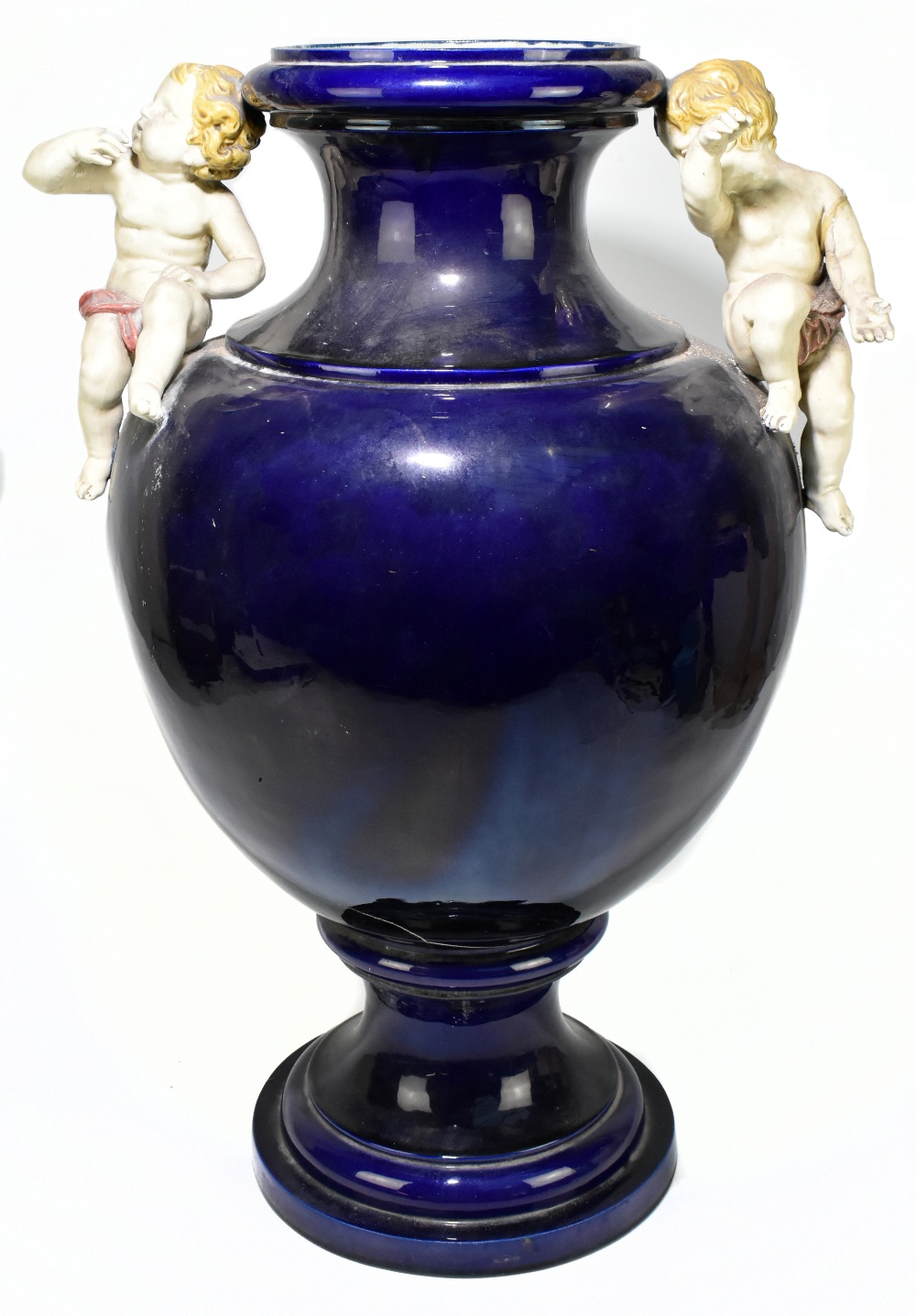 PARIS 1878; a very large blue glazed majolica twin handled vase set with cherubs beside the flared