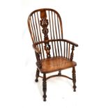 A mid-19th century yew wood high hoop back Windsor elbow chair, with pierced splat, dished elm seat,