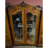 A French walnut armoire with two bevelled mirrored doors raised on carved cabriole front legs.