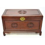 A 20th century Chinese carved rosewood blanket chest, with stylised decoration raised on bracket