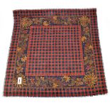 YVES SAINT LAURENT; a wool and silk red, black and brown checked scarf with a paisley border, the