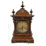 JUNGHANS; an early 20th century oak cased mantel clock, with turned wooden finials and applied