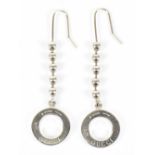 GUCCI; a pair of silver drop earrings with signature embossed 'Gucci' to front, with silver ball