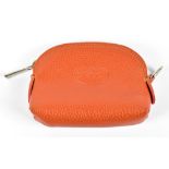 LONGCHAMP; an orange pebbled leather small coin purse with silver tone hardware top zip and buckle