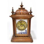 A late 19th century walnut mantel clock with circular dial set with Roman numerals within a framed