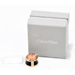 CALVIN KLEIN; a gold tone and brown embossed leather ring, size medium, and stamped externally ‘