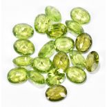 PERIDOT; twenty faceted oval cut 9 x 7mm stones.