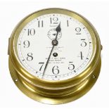 An early 20th century circular brass ship's clock, the dial set with Arabic numerals and