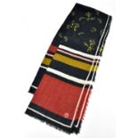 BAUM UND PFERDGARTEN; a 100% wool woven black, beige, rust red and cream woven scarf embellished