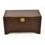 A mid-20th century Chinese carved camphorwood blanket chest decorated with prunus and Greek key