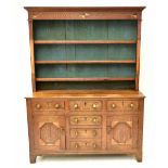 A George III inlaid oak dresser, the raised back with three shelves, and side supports inlaid with