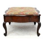 A Victorian walnut serpentine footstool, with hinged upholstered seat, on cabriole legs carved