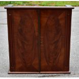 An Edwardian two door table top cupboard, with oval panelled doors enclosing a shelf, height