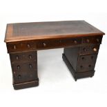 A late Edwardian stained mahogany pedestal desk, with an arrangement of nine drawers on plinth base,