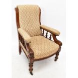 A late Victorian walnut salon chair, with patterned upholstery, with open arms and turned legs,