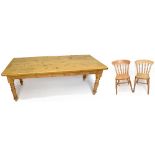 A pine reproduction dining table raised on turned column legs, and a set of eight pine kitchen