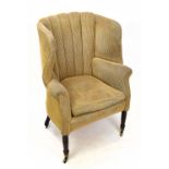 A Regency stained mahogany wingback tub chair, with shaped back, on ring turned legs with fitted