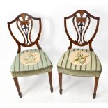 A pair of Edwardian Hepplewhite style inlaid mahogany dining chairs, with shield shaped backs on