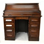 An early 20th century oak roll-top desk, with tambour enclosing a fitted interior above two