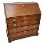 A George III oak bureau, with fall front enclosing a fitted interior, above four long graduated