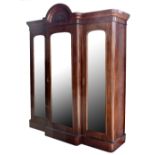 A Victorian mahogany breakfront wardrobe, with three bevelled mirrored doors, on plinth base, height