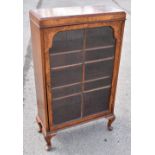 A 1930s walnut display cabinet, with astragal glazed door, on cabriole legs, height 107cm, width