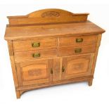 An Arts & Crafts light oak sideboard, with carved gallery back above an arrangement of four