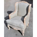 A modern Louis XV style carved wooden fauteuil carved with pale blue upholstery on cabriole legs,