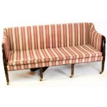 A Regency and later carved mahogany settee, with later striped upholstery and fluted curved arms