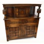 A 17th century style carved oak court cupboard, with panelled door above two drawers and two