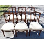 A set of six late Victorian carved walnut dining chairs, with upholstered seats on turned and fluted