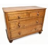 A reproduction pine chest of two short over two long drawers raised on bun feet, width 105cm, height