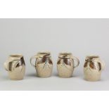 A set of four stoneware mugs covered in oatmeal glaze with iron and cobalt decoration, impressed JDC