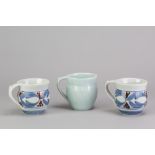 DEREK EMMS (1929-2004); a pair of porcelain mugs with cobalt and copper red decoration on white