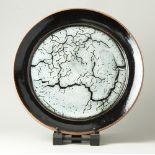 TOM KNOWLES JACKSON (born 1973); a large stoneware charger covered in tenmoku and naturally