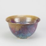ABDO NAGI (1941-2001); a stoneware bowl covered in streaky blue and red glaze on green ground,