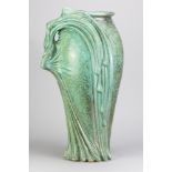 A large earthenware vase in the Art Nouveau style covered in copper green patina glaze, the side