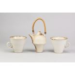 PAUL BRADLEY; a pair of stoneware mugs covered in white glaze with bronze rims, impressed marks,