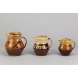 PATRICK GROOM (born 1932) for Winchcombe Pottery; three slipware jugs with iron decoration on yellow