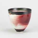 EDDIE CURTIS (born 1953); a deep porcelain bowl partially covered in copper red glaze with manganese