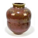 A Chinese style vase, possibly Ming, of waisted ovoid form, with a mottled red glaze, lacking four