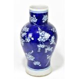 An early 20th century Chinese blue and white vase decorated with prunus on a cobalt blue ground,