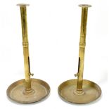 An unusual pair of 19th century brass ejector candlesticks, with integrated circular drip trays,