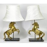 A pair of cast brass and green marble table lamps modelled as Marly horses, the rearing horses