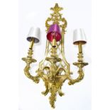 A large gilt metal wall light, the pierced shaped backplate supporting three scrolling arms,