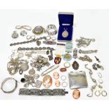 A group of costume jewellery including three silver charm bracelets, silver bangles, brooches,