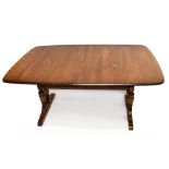 ERCOL; a stained oak extending dining table, height 72cm, width 155cm, depth 100cm.